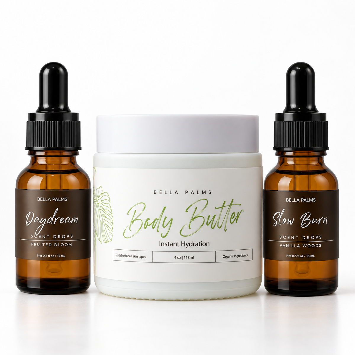 Three Bella Palms products arranged on a white background: a white jar labeled Body Butter in the center, flanked by two amber dropper bottles labeled Daydream Fruited Bloom Scent Drops and Slow Burn Vanilla Woods Scent Drops.
